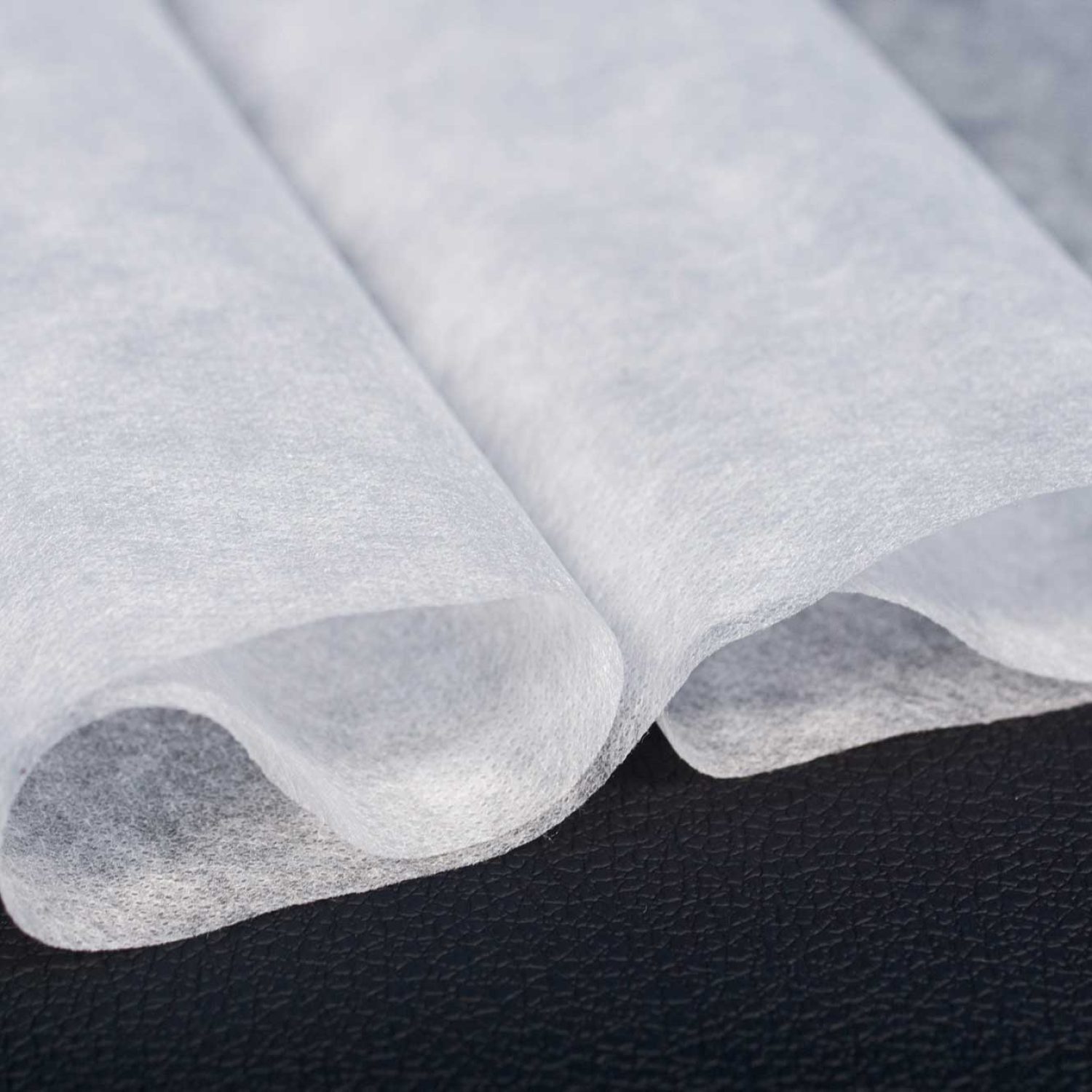 Rollos de tejido sin tejer en acabado suave, ideales para la fabricación de bolsas reutilizables y embalaje ligero.