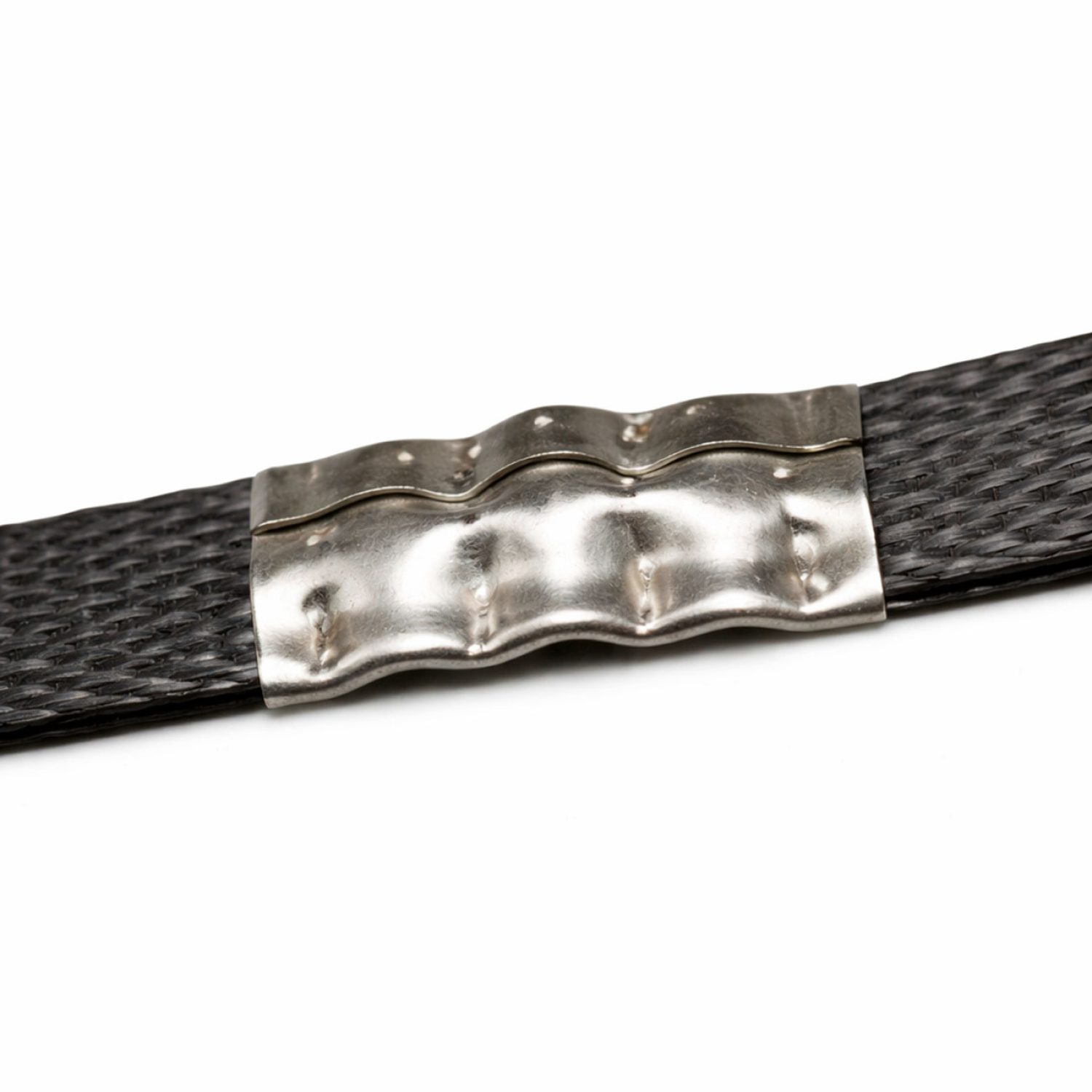 Detalle de unión metálica para fleje, engarzada sobre cinta de embalaje para asegurar y tensar cargas en palets con máxima resistencia.